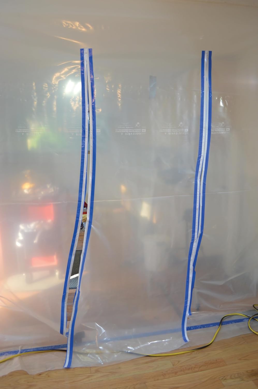 Cloison de confinement en polyéthylène avec deux fermetures éclair adhésives bleues installées