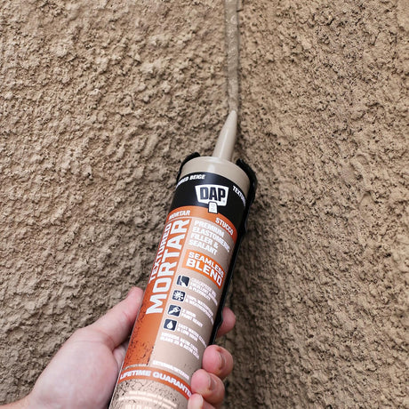 Application du scellant texturé DAP sur une fissure de mur en stuc beige