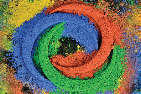 Pigments en poudre bleu, vert et orange disposés en spirale